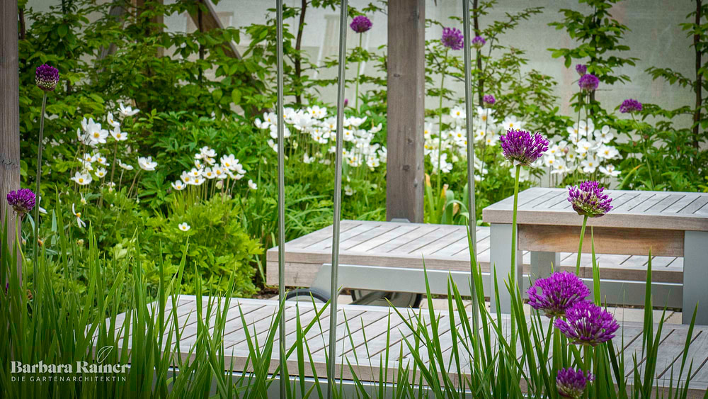 Gartendesign von Barbara Rainer für zufriedene Kunden. Liegestühle in einer frischen grünen bunten Bepflanzung von Barbara Rainer